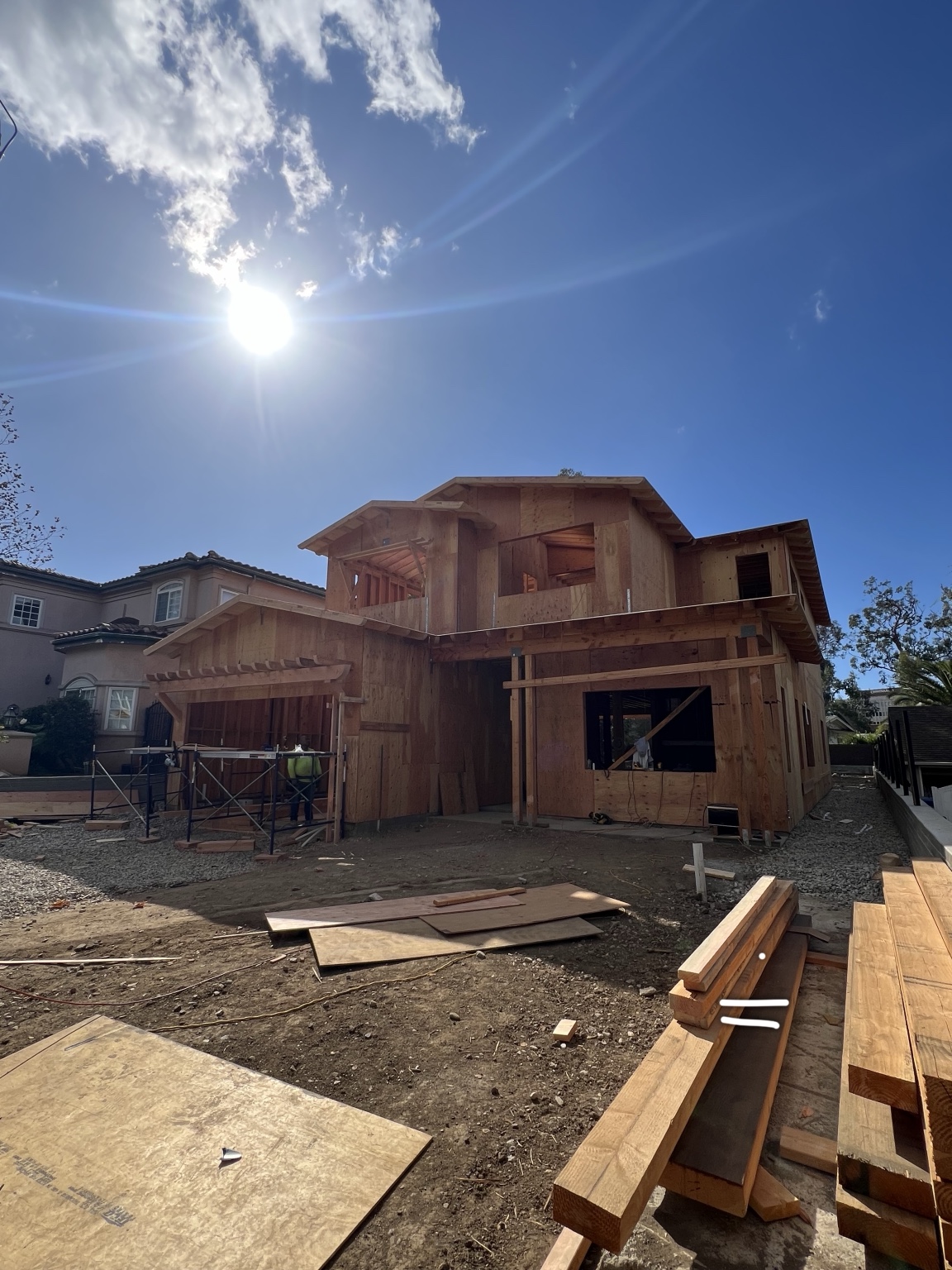 Two-story home under construction with exposed framing